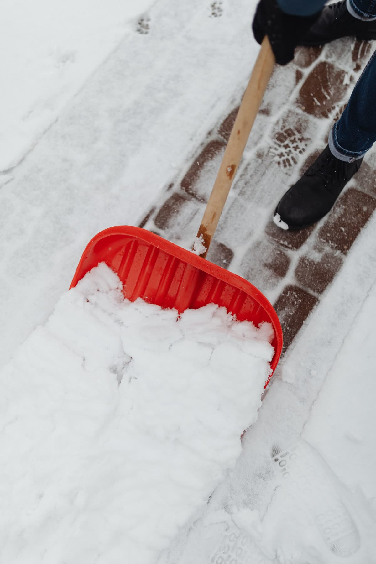Schneeschaufel auf einem geräumten Gehweg