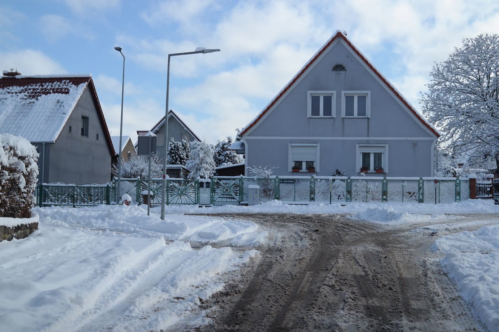 Verschneite Wohnstraße mit geräumtem Weg